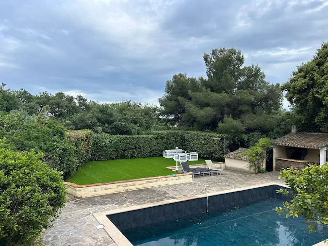 Jardin entretenu avec haie taillée, pelouse et piscine