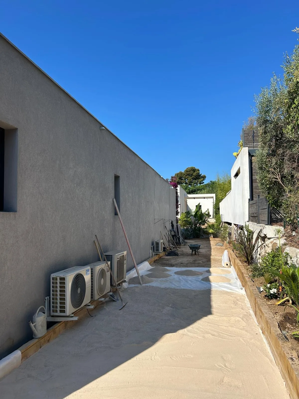 Terrain de pétanque en cours, sable étalé le long d’un mur